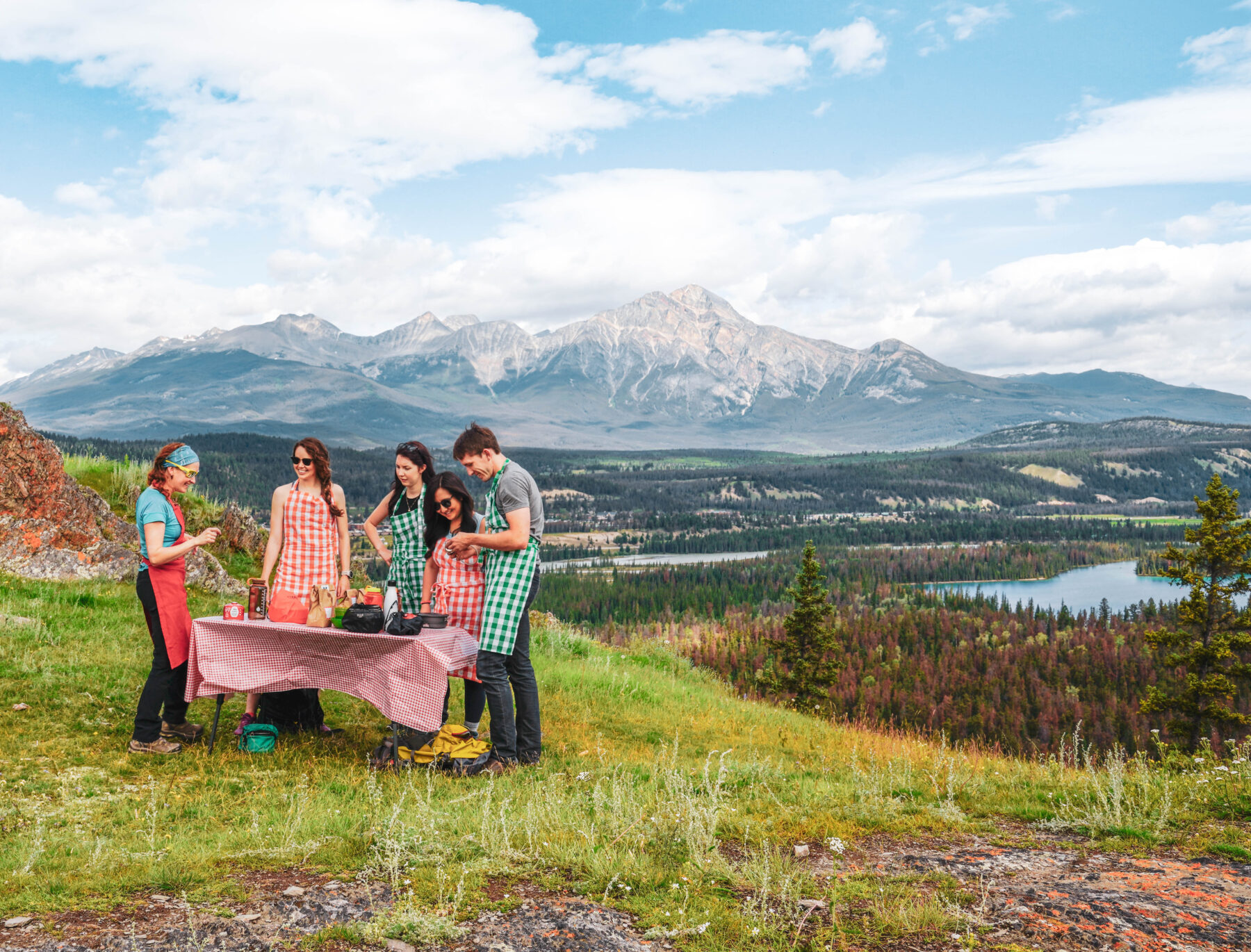 Guests enjoying a cooking lesson on top of a mountain peak in Jasper, Canada