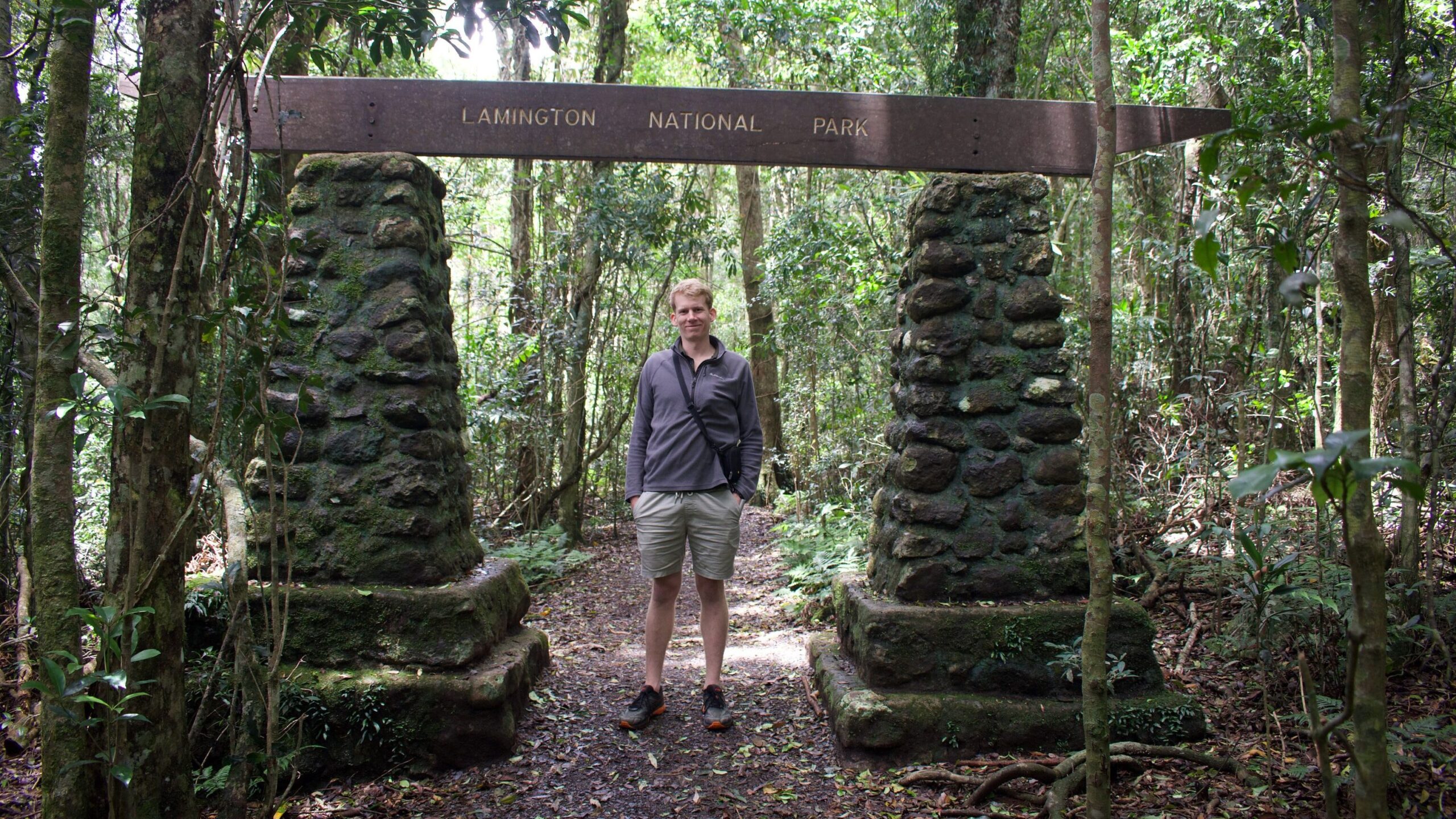 James Tweed standing at the entrance of Lamington National Park.