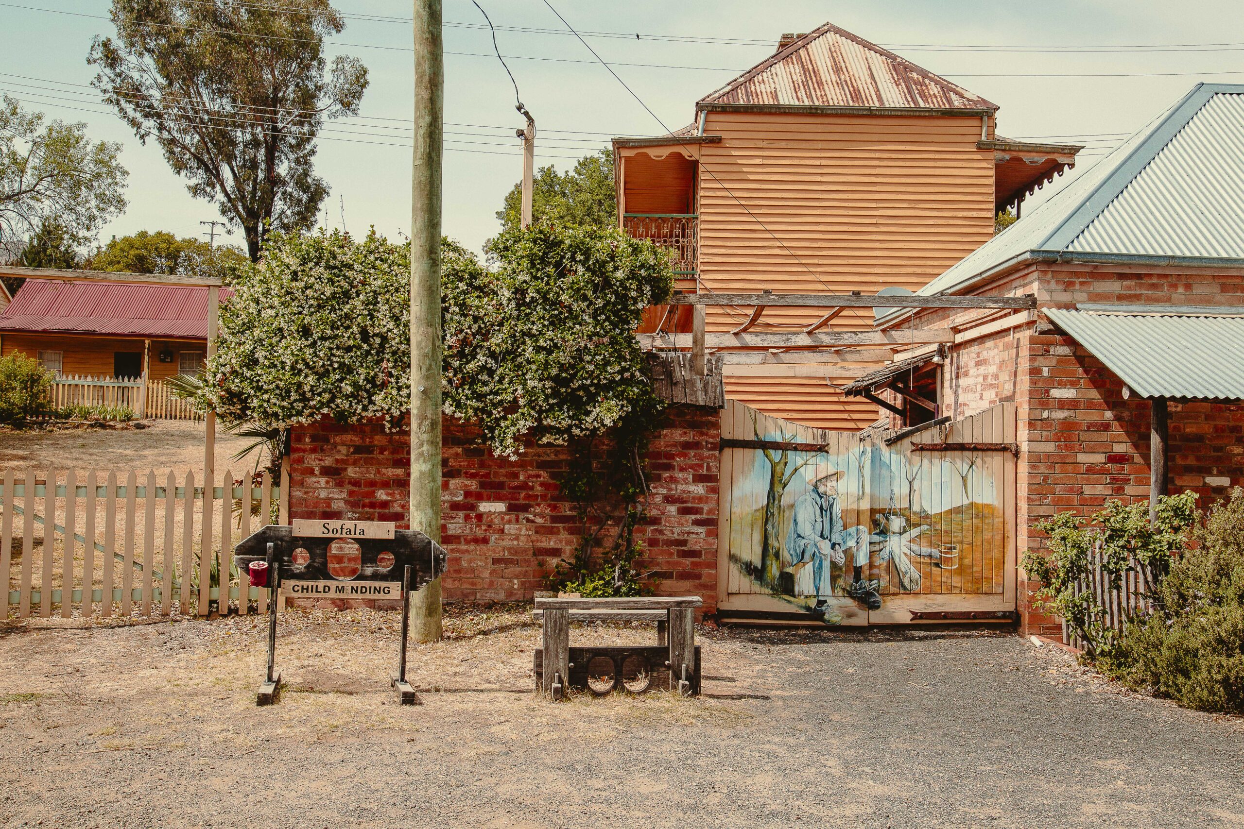 A mural of a man by a campfire on a wall in Sofala, New South Wales.