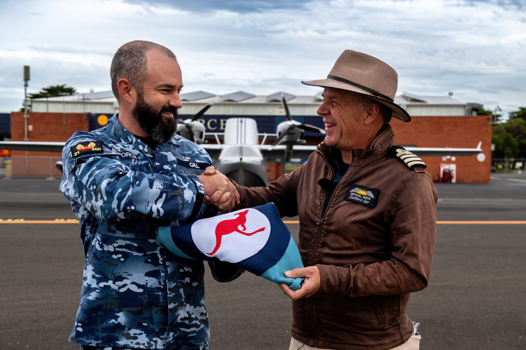 In front of the 100 Squadron hanger at RAAF Base Point Cook and the Chaika LLC L65 Seabear Southern Sun, Wing Commander Robert Gill commanding officer of 21 Squadron presents Michael Smith, 2016 Adventurer of the Year with a RAAF ensign to carry with him as he recreates the first circumnavigation by air of Australia that took place 100 years ago. *** Local Caption *** Adventurer, Michael Smith is flying solo around the Australian coastline to
commemorate the 100th anniversary of the first flight around Australia by Air Forces acting Chief of the Air Staff, Wing Commander S.J. (Jimmy) Goble, and pilot, Flying Officer Ivor McIntyre in the original Fairey IIID seaplane A10-3. Starting from the Royal Australian Air Force (RAAF) base
in Point Cook, outside Melbourne in his seaplane SouthernSun twin engine Chaika LLC L65 Seabear.