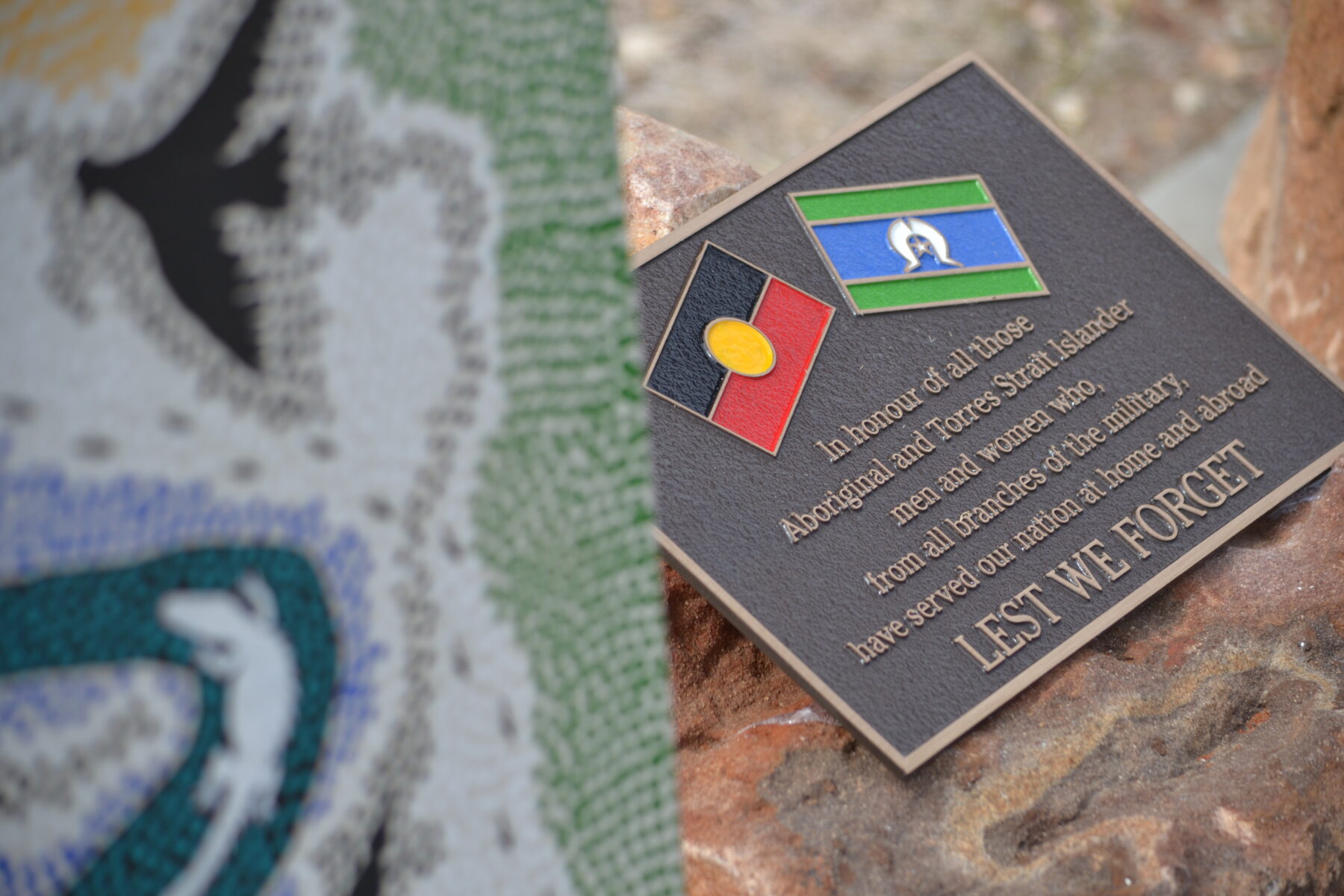 A memorial plaque with the Aboriginal and Torres Strait Islander flags that reads "In honour of all those Aboriginal and Torres Strait Islander men and women who, from all branches of the military, have served out nation at home and abroad LEST WE FORGET"