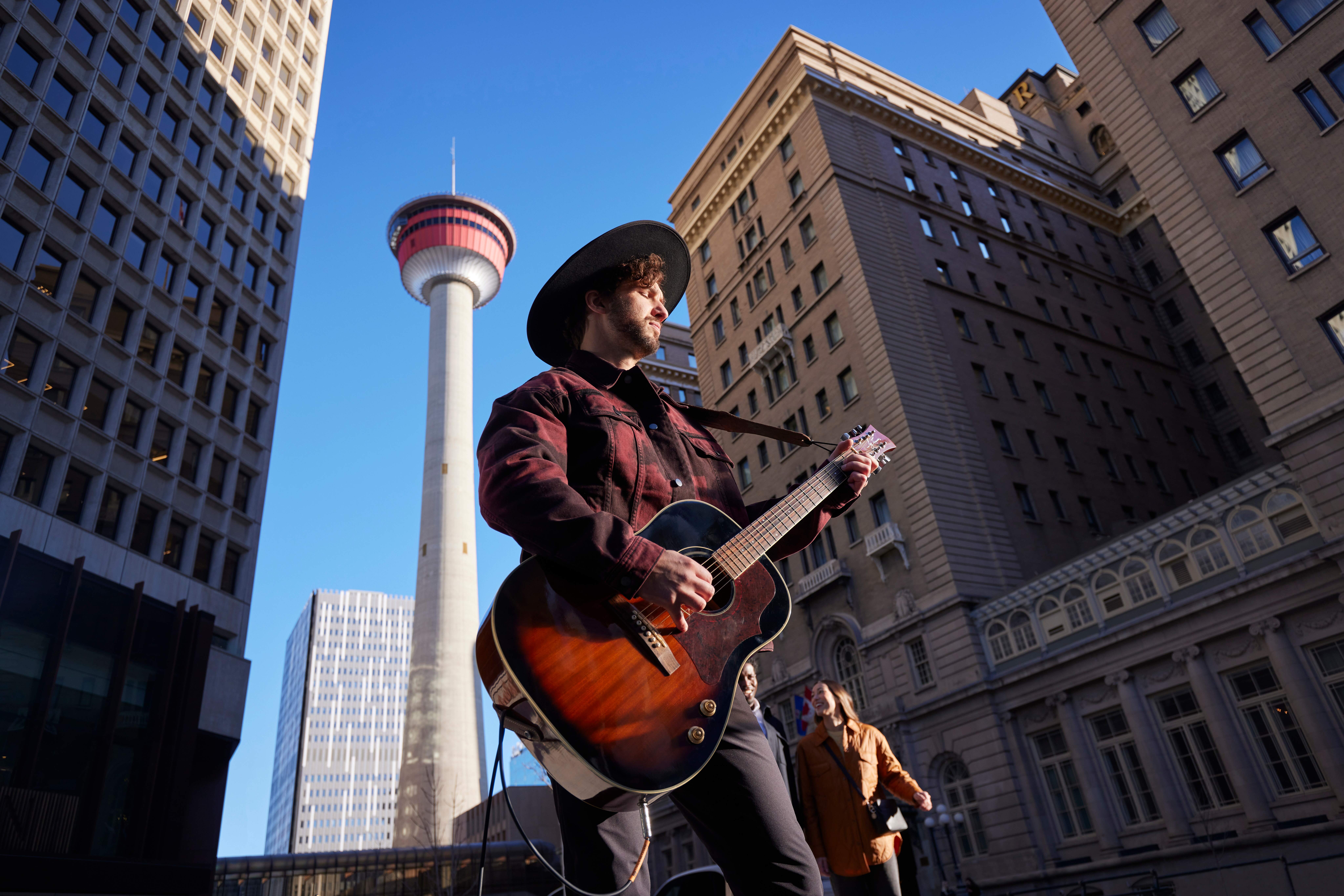 A busker playing guitar on the streets of Calgary