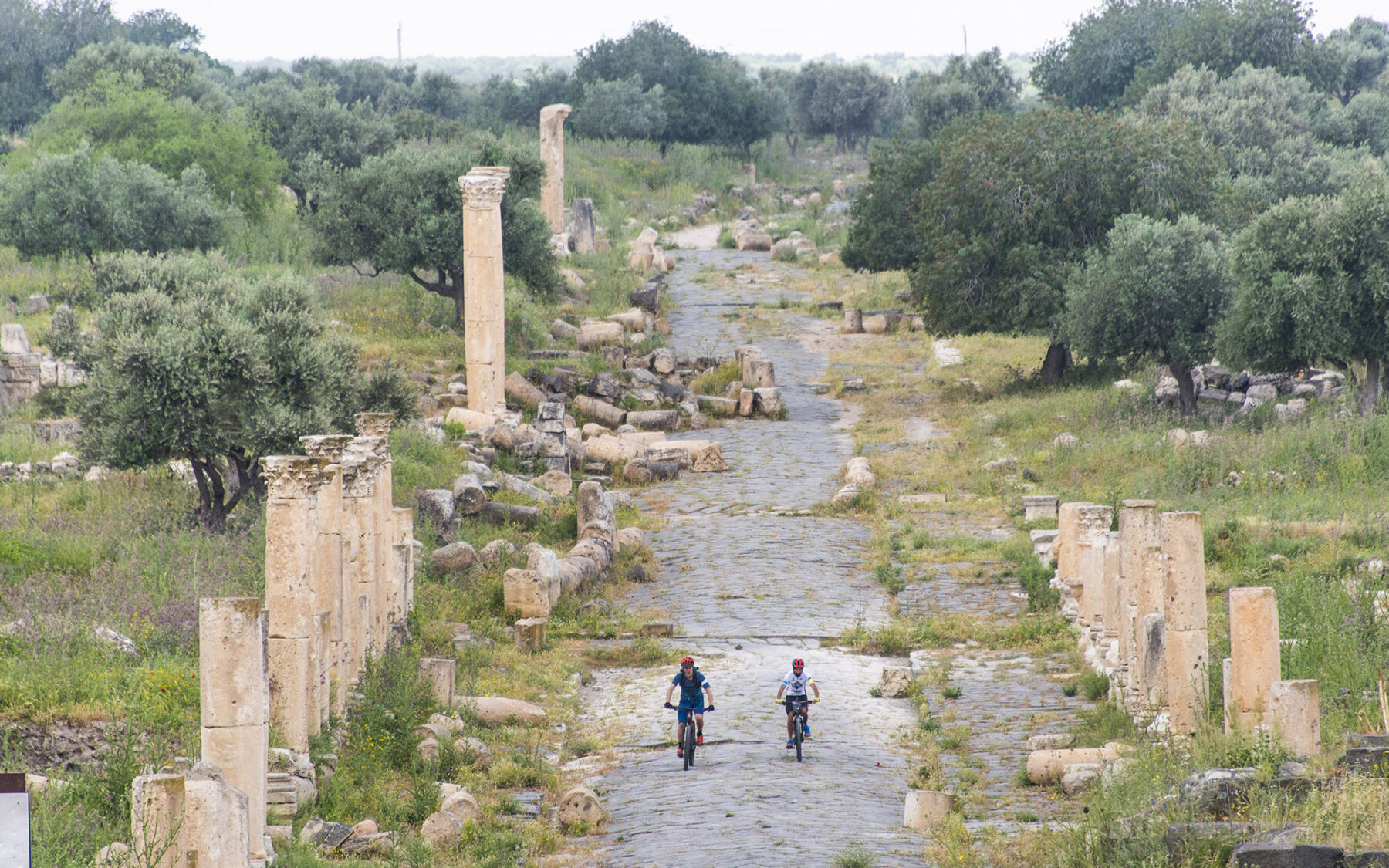Andrew Findlay and Sari Husseini (Cycling Jordan) ride an ancient road in the ruins of Gadara in Umm Quais, Jordan.