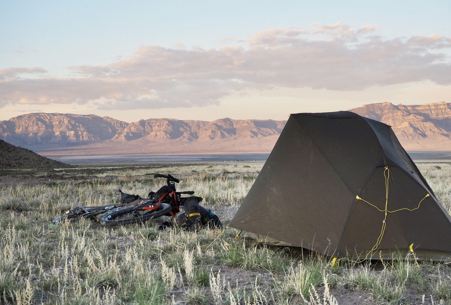 A bike on the ground next to a tent