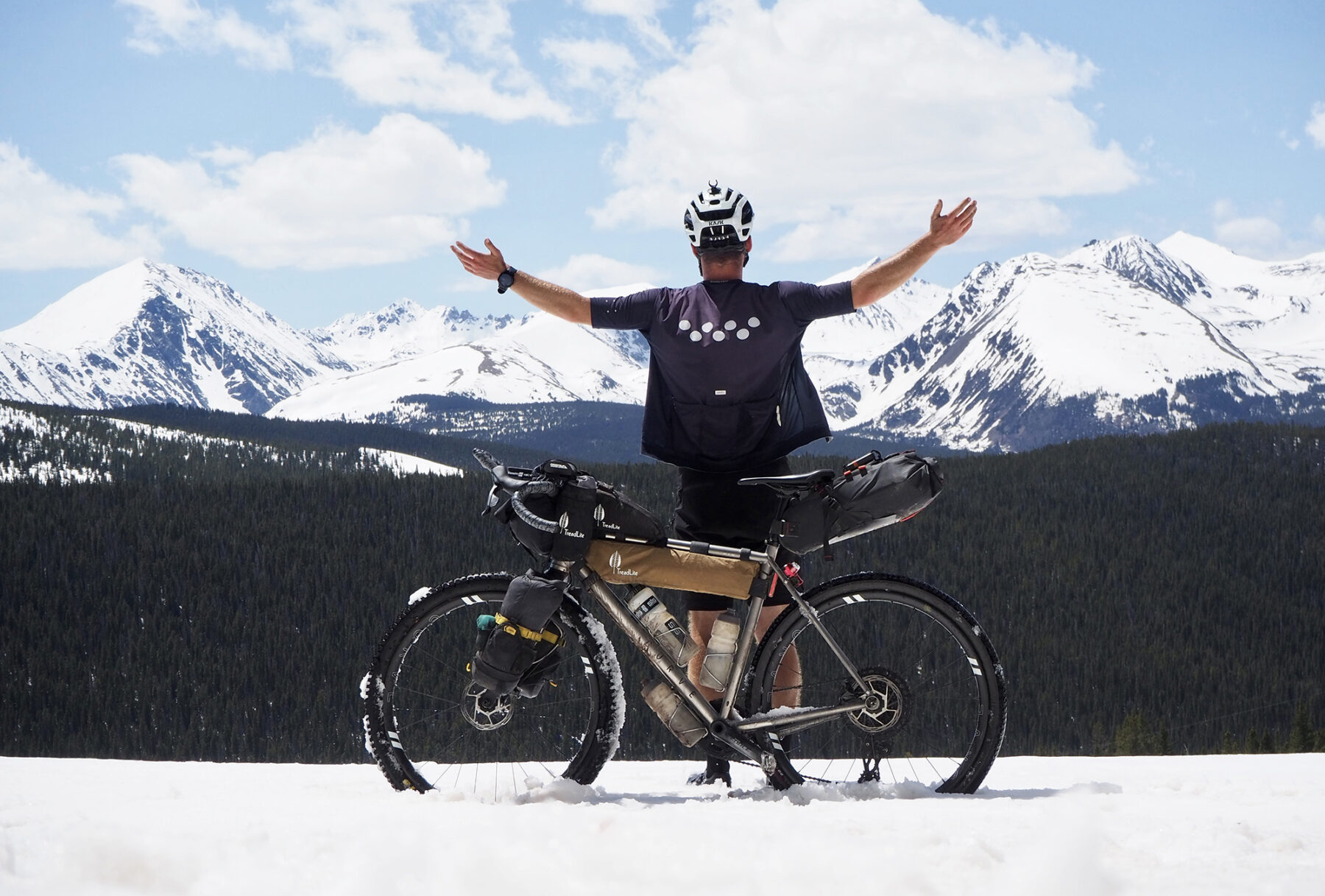 Jimmy Ashby beside his bike on a snowy mountain