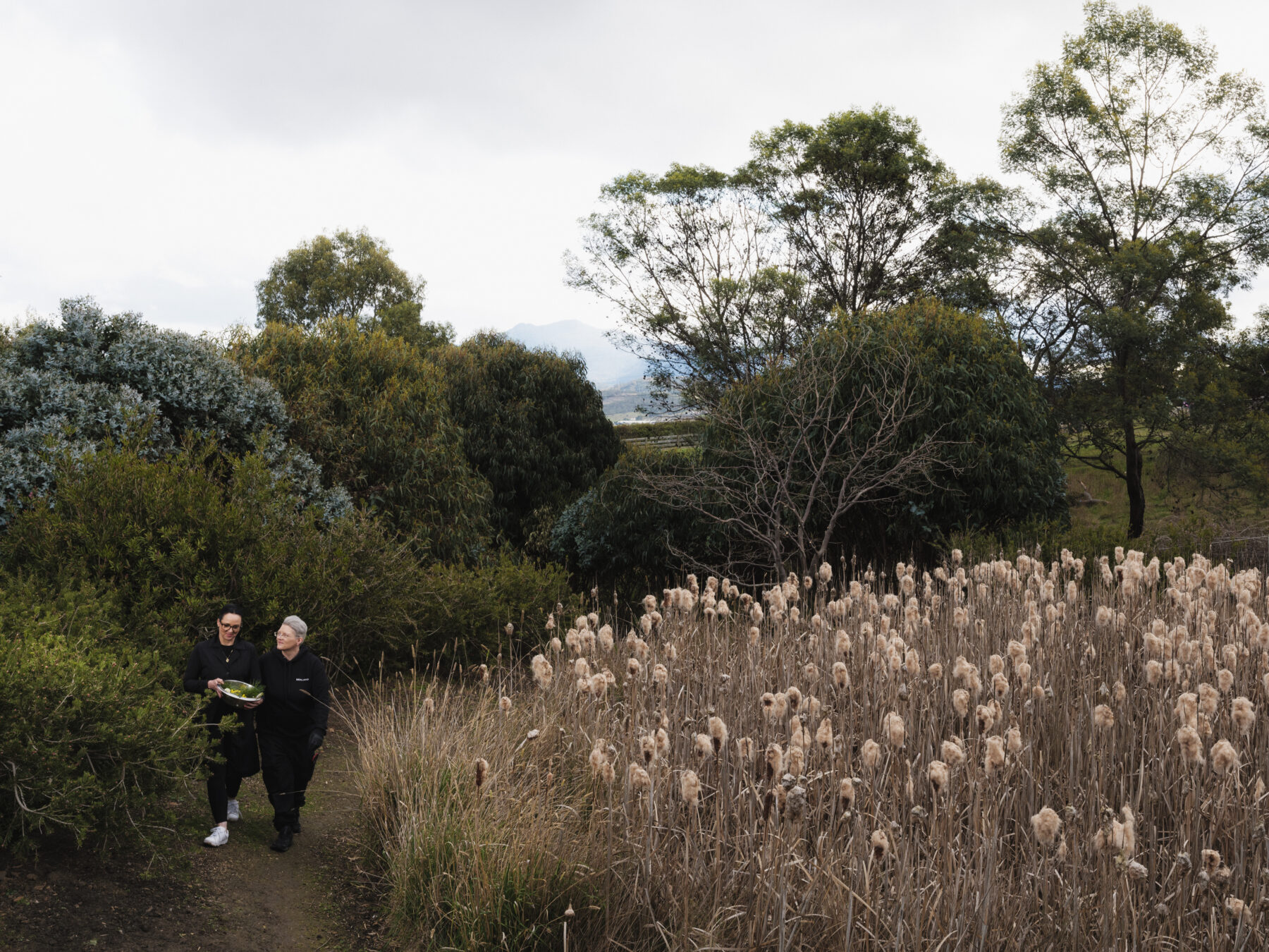 Masey and Maryka walk through their garden in Honeywood, Tasmania