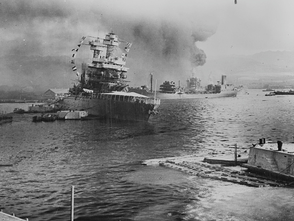 Amid Japanese fire, the fleet oiler USS Neosho (pictured in background) escapes from Pearl Harbor