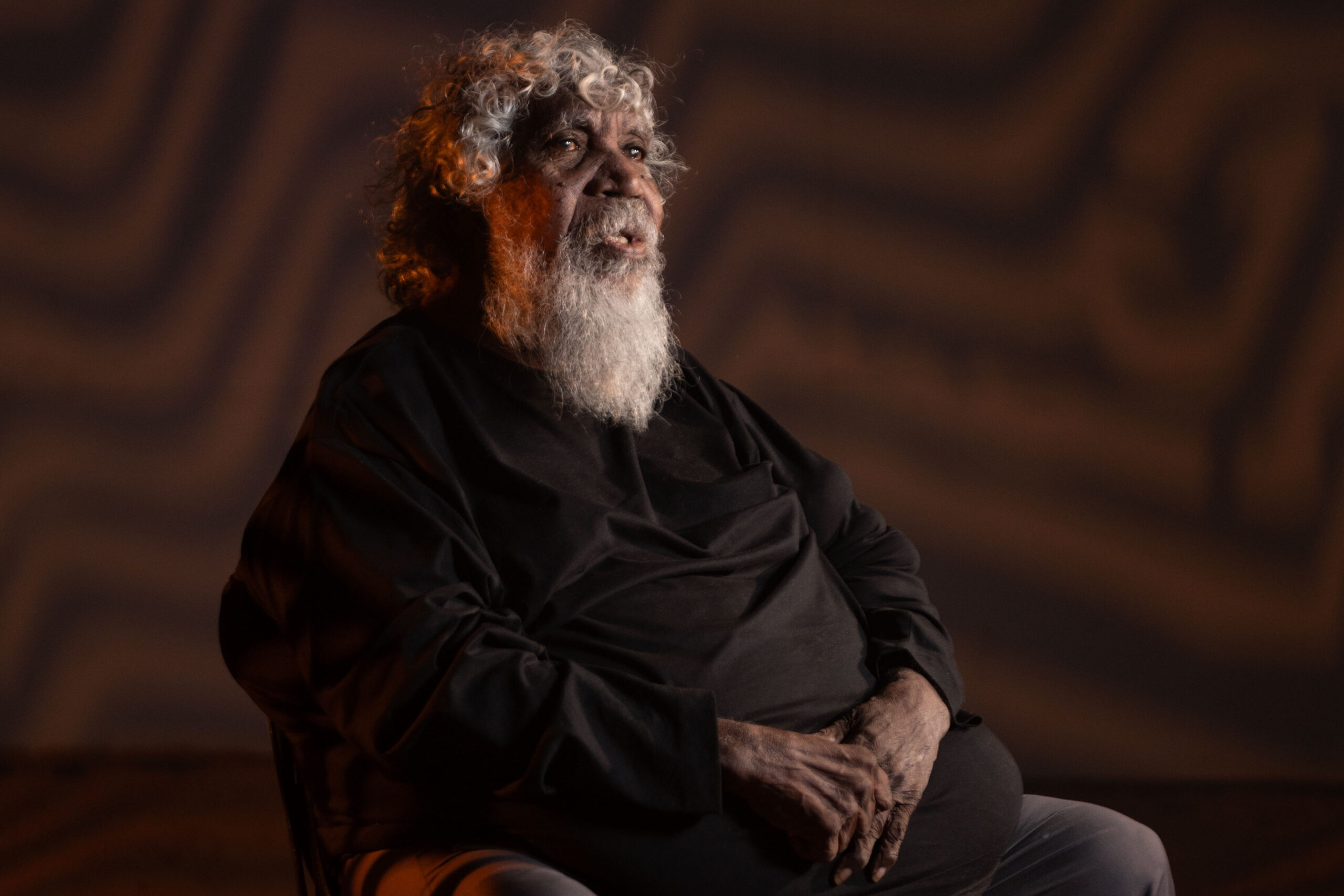 Bobby West Tjupurrula in front of his artwork 'Hypnotic Reverberations'